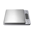A silver digital pocket scale with a tray and several measurement buttons.