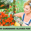 A woman wearing green gardening gloves is tending to bright orange flowers in a garden setting.