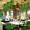 Artificial green hanging vine greenery decorating an office space with modern furniture.
