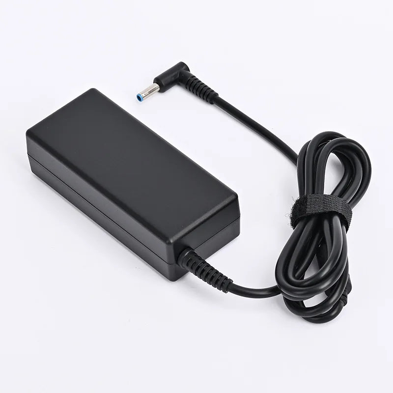 Schwarzes universelles Laptop-Netzteil mit gewickeltem Kabel und Stecker.