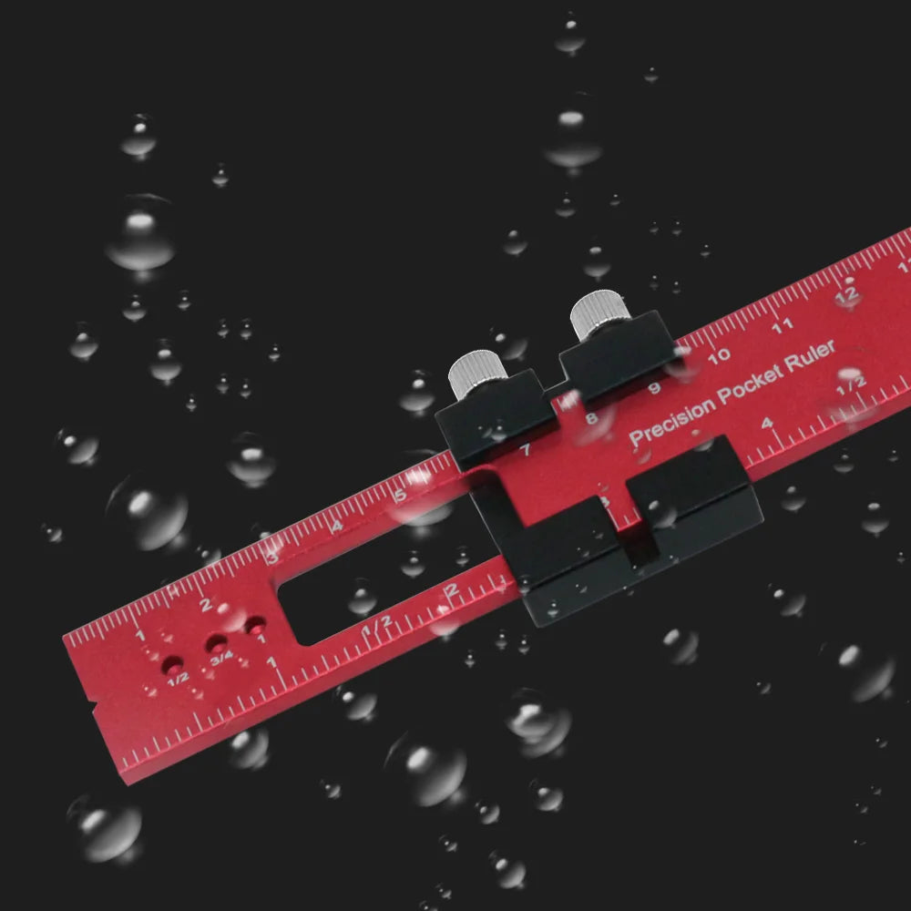 A red aluminum pocket ruler with a black T-track slide stop is shown against a dark background with floating water droplets.
