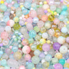 A close-up view of mixed sizes glass beads in various pastel colors including pink, blue, yellow, and green.