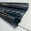 A close-up view of a dark gray ceramic car window tint film rolled onto a white rod.