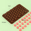 A brown silicone mold with numerous heart-shaped cavities, showing a scale for size.