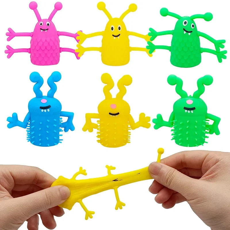 A set of five colorful monster-shaped finger fidget toys, including pink, yellow, green, blue, and lime green, are shown bein
