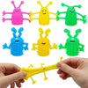 A set of five colorful monster-shaped finger fidget toys, including pink, yellow, green, blue, and lime green, are shown bein