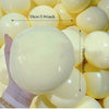 Eine Hand hält einen großen, glatten, blassgelben Stressabbau-Squishy-Fidget-Ball mit Messanzeige.