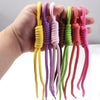 A hand holds several colorful braided nylon lanyards or keychains in various shades of yellow, purple, green, and pink.