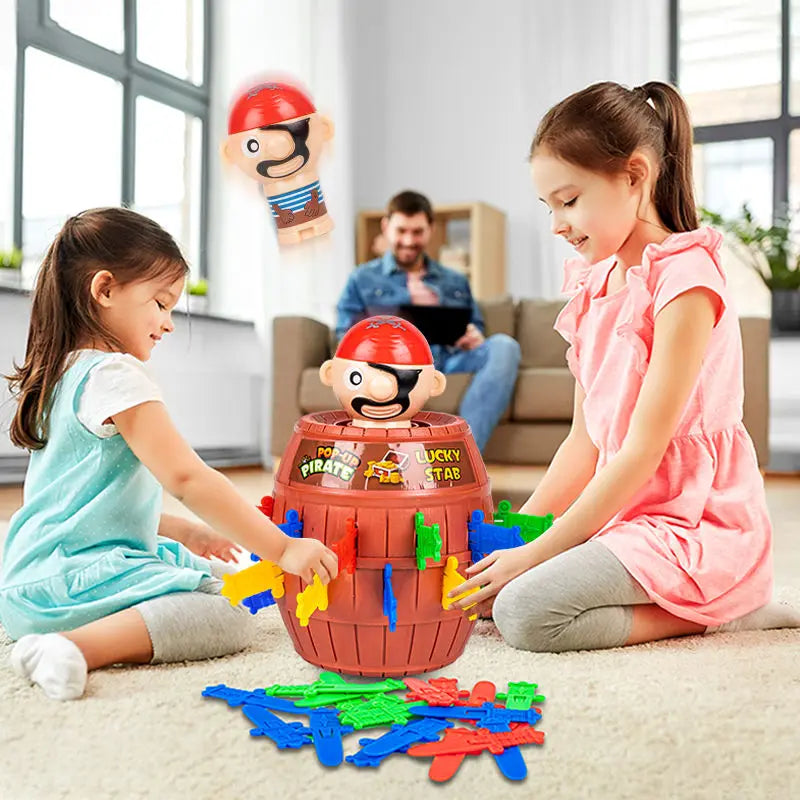 A girl and a boy play with a jumping pirates board game featuring pirate figures and colorful plastic pieces on a rug.
