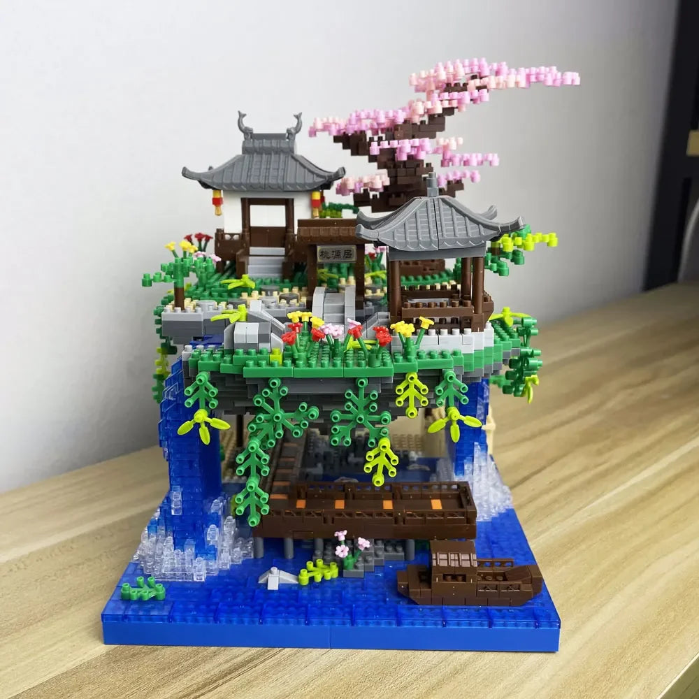 A miniature building block set depicting a traditional Japanese treehouse with pink blossoms and greenery.