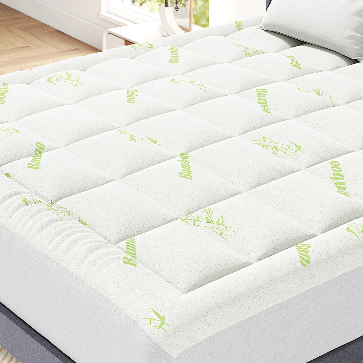 Dessus de matelas en viscose de bambou blanc avec motif de feuille verte sur un lit.
