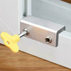 A silver aluminum alloy sliding window lock with a yellow handle and hex key is mounted on a white frame.