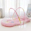 Pink portable crib mosquito net with a pillow and cotton pad on a white surface.