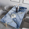 A marble-patterned table set with gray chairs and decorative items on a light blue surface.
