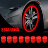 A close-up of a car wheel with a red glowing ring, next to eight red tire valve caps.
