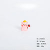 A small pink resin figurine of a pig with a yellow crown, used as miniature garden or desk décor.