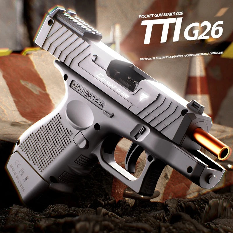 A silver pistol, the TTI G26, is shown in a close-up view resting on a dark surface.