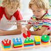 A puzzle game column set of multi-shape, multi-color stacking blocks being played with by two young children.