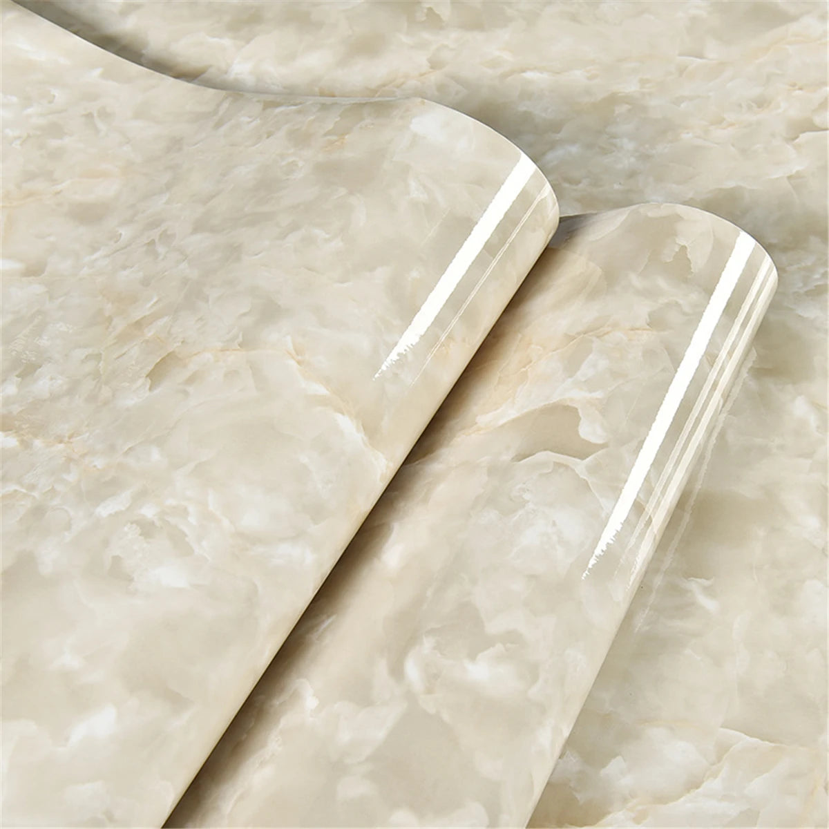 A close-up of glossy, self-adhesive vinyl wallpaper in a pale beige marble pattern.