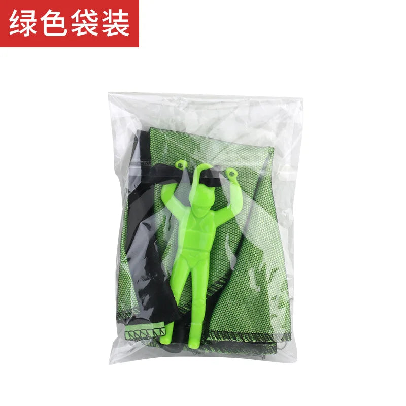 A green parachute toy with a mini soldier figure inside a clear plastic bag.