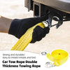 A hand is attaching a yellow tow rope with metal hooks to a vehicle hitch, demonstrating a strong and durable towing rope.