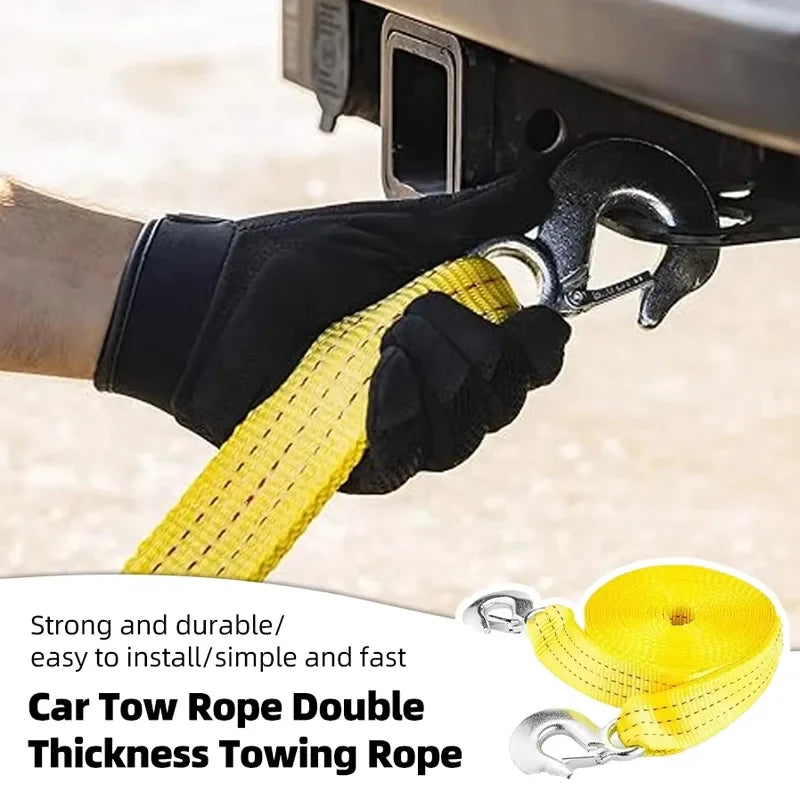 A hand is attaching a yellow tow rope with metal hooks to a vehicle hitch, demonstrating a strong and durable towing rope.