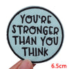 A light blue embroidered patch with black text that reads You're stronger than you think.