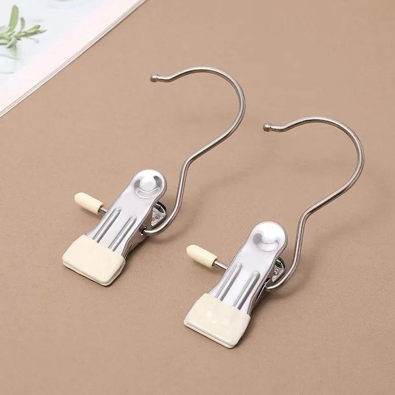 A pair of stainless steel clothespins with hooks used as a space-saving closet organizer.