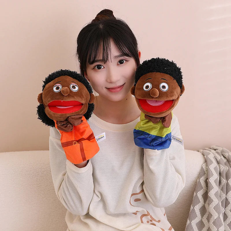 A young woman holds two soft plush hand puppets, one brown and one dark, against a light background.