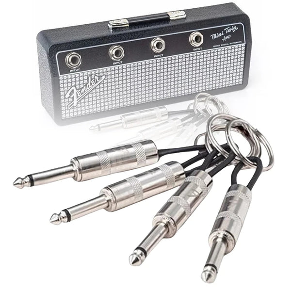 A Mini Twin amp guitar pedal with multiple output jacks and a set of guitar plugs.