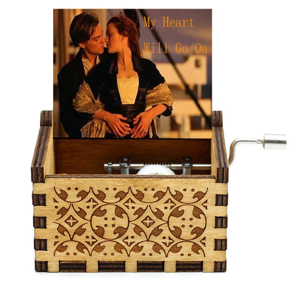 A vintage hand-crank wooden music box with a decorative wooden box and a brass crank handle.