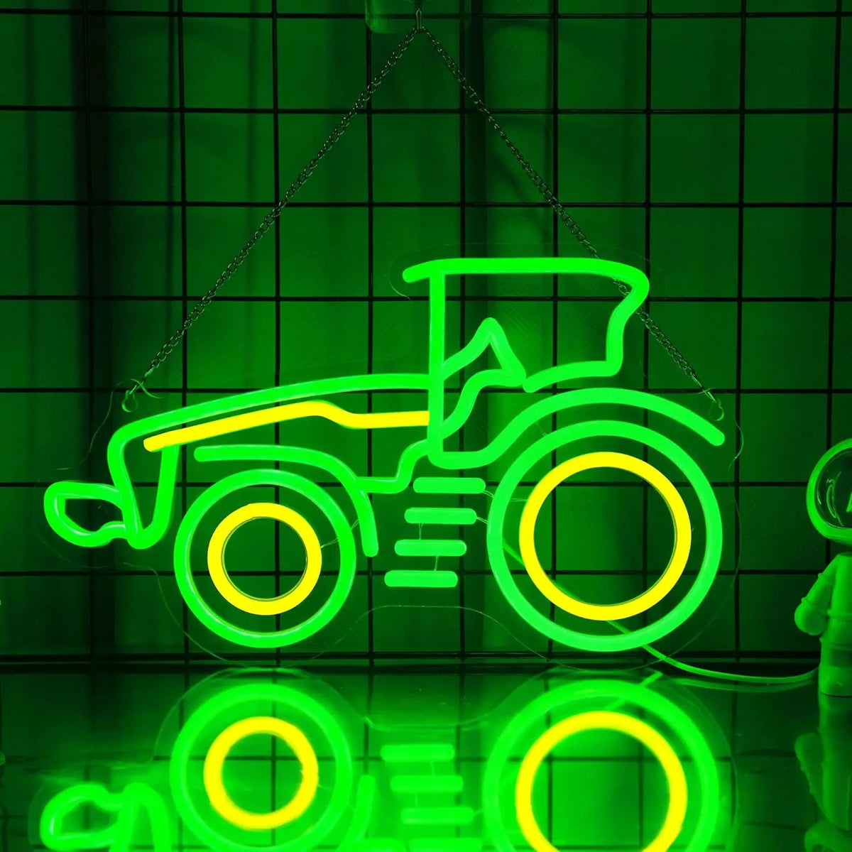A neon sign shaped like a tractor, glowing green and yellow, is displayed against a dark green grid background.