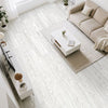 A bright, modern living room featuring light wood grain floor tiles, a beige sofa, and a white coffee table.