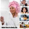A woman wearing a pink satin sleeping bonnet is shown in a bathroom setting, demonstrating its use for hair care.