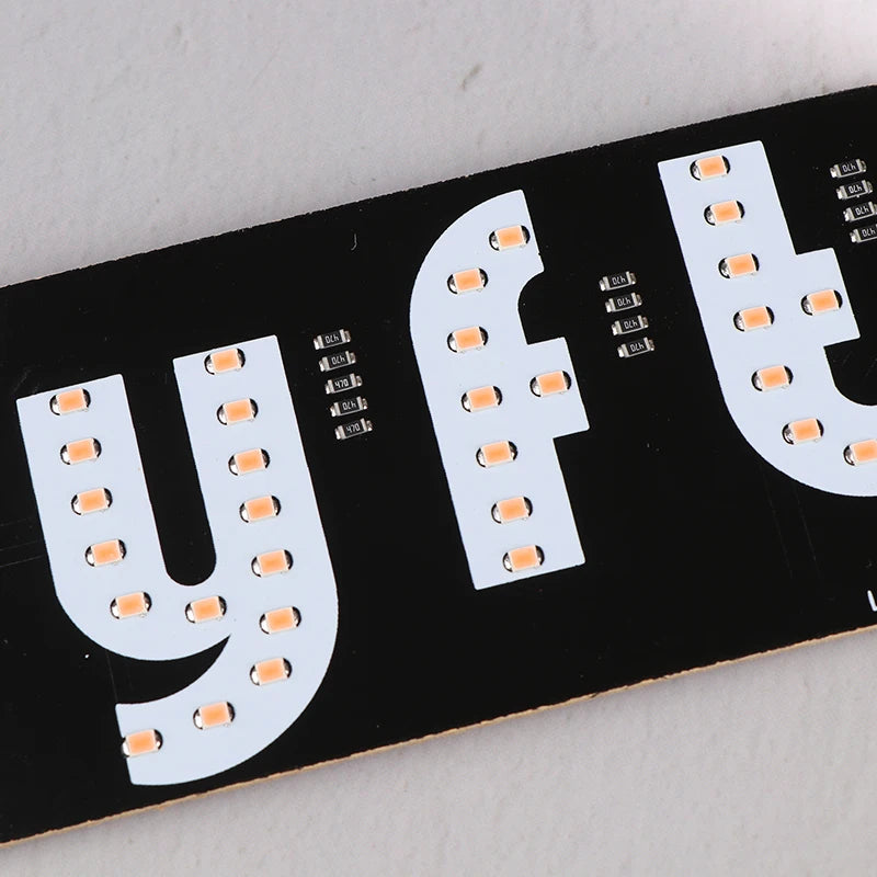 A black sign featuring the letters YFT in white LED lights, designed for ride-share vehicles.