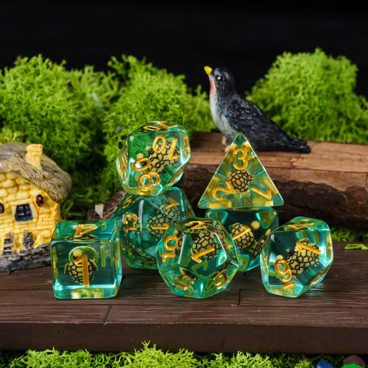 A set of adorable animal resin dice, including a black bird figurine and various colored dice, displayed on a wooden surface 