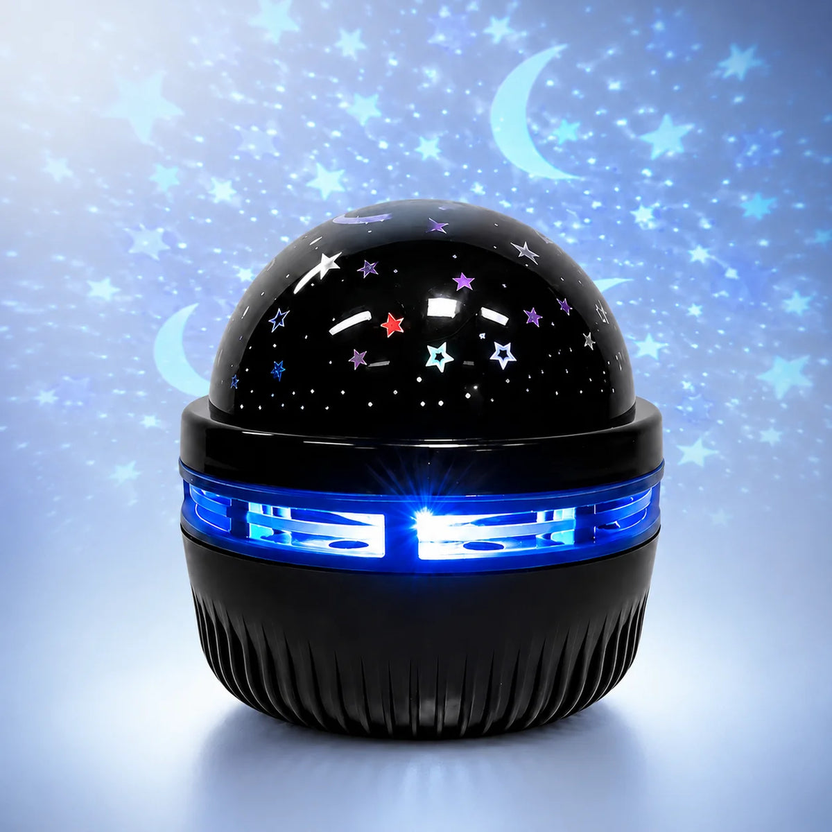 A black projector night light with a dome featuring stars and a blue light ring, set against a starry background.