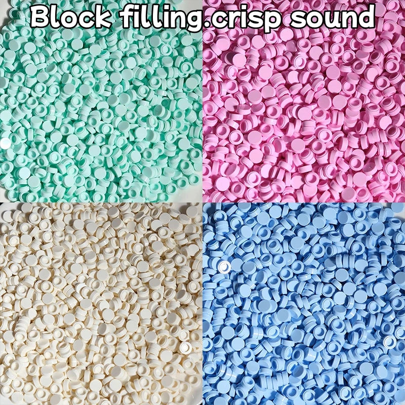 A close-up of colorful plastic beads or pellets in various shades of green, pink, and blue.