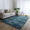 A deep blue velvet plush carpet placed on a wooden floor in a bright living room setting.