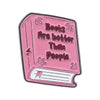 Pink enamel pin featuring text that reads Books Are better Than People on a book design