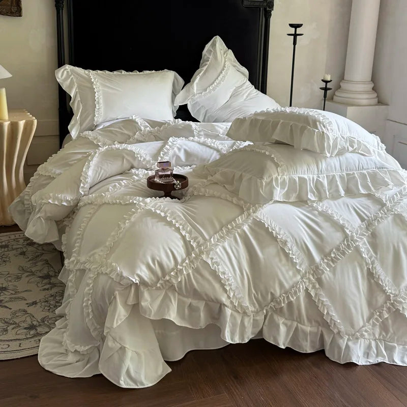 A white ruffled duvet cover set with pillows and a decorative throw on a bed.