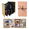 Ein Set aus schwarzen Klapp-Fotobüchern und eine pinke Geschenkbox mit brauner Schleife.
