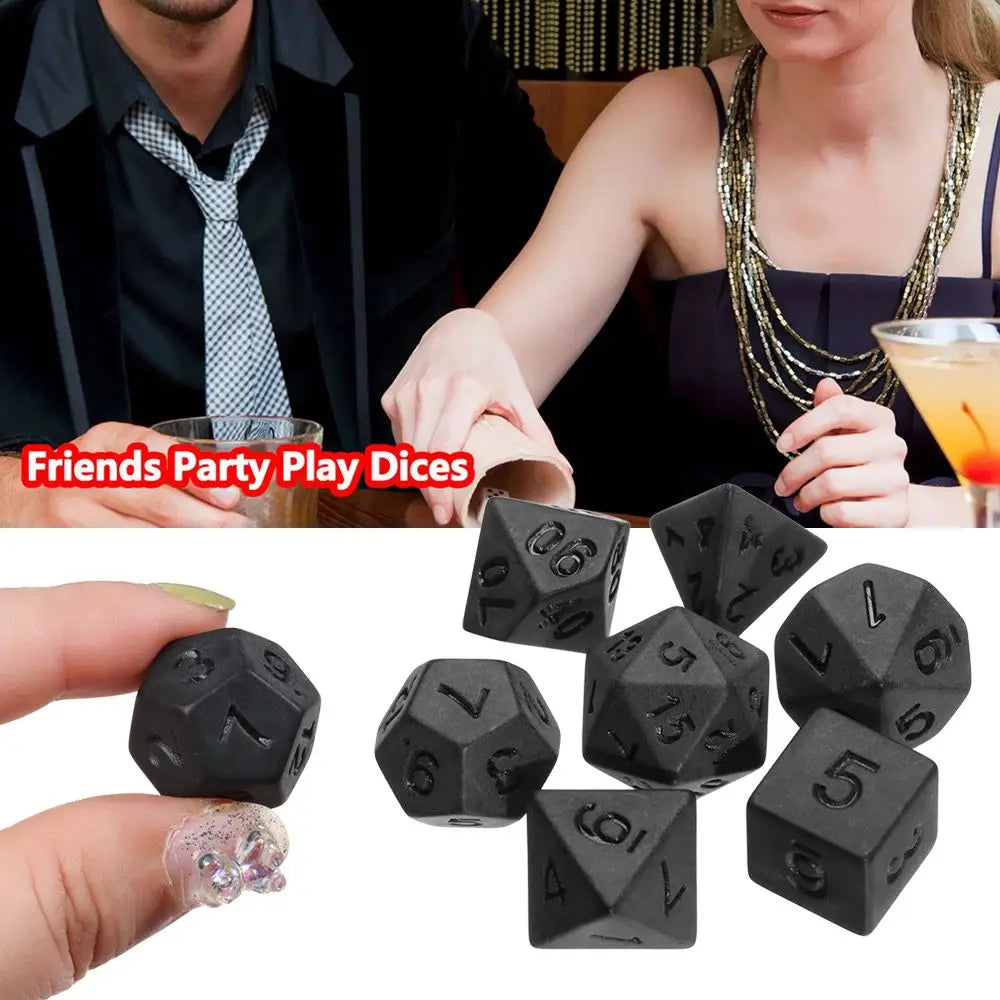 A set of matte black polyhedral dice for tabletop role-playing games shown being held by a hand.