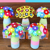A colorful craft kit featuring felt flowers and buttons arranged in bouquets in glass vases.