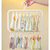 A white clip laundry drying rack with various colored fabric clips hanging from it.