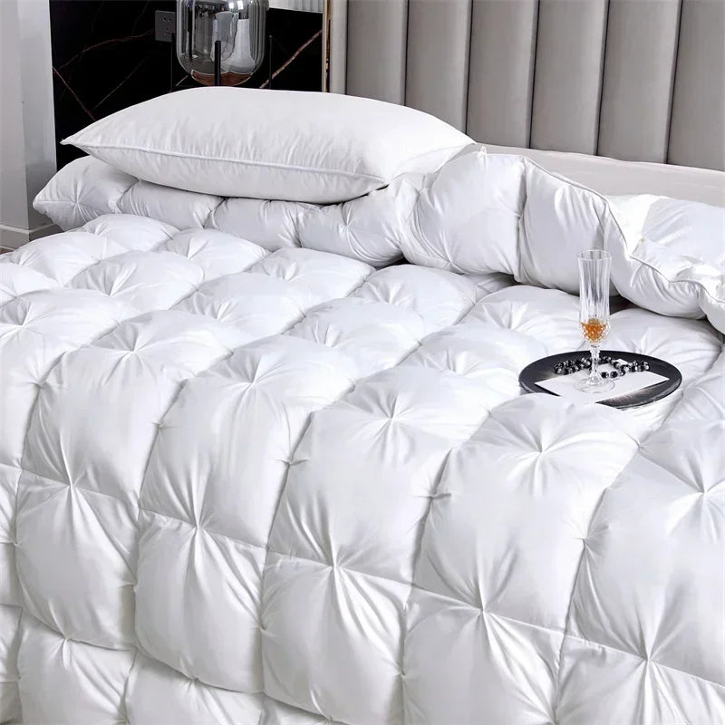 A fluffy white goose down comforter is displayed on a bed, featuring quilted patterns.