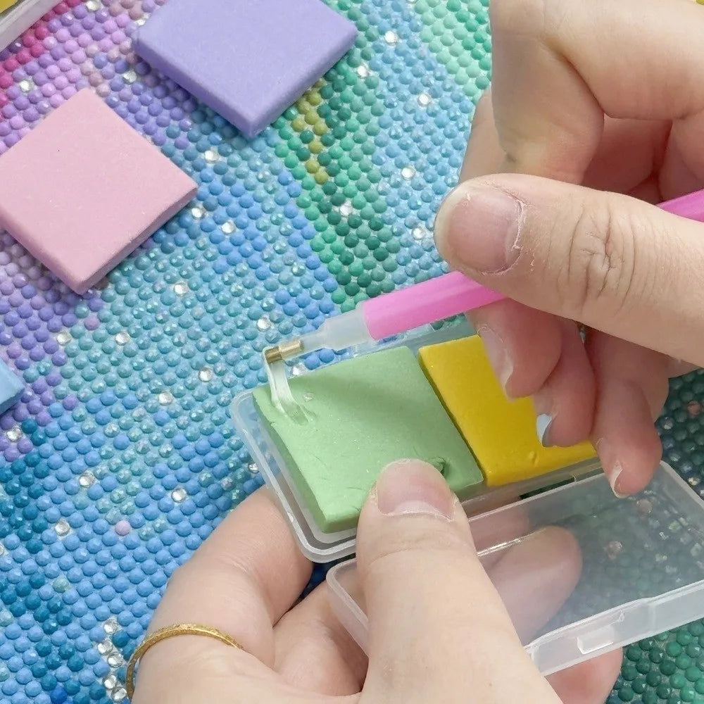 Hands are applying silicone diamond painting clay with a pink stick onto a clear container.