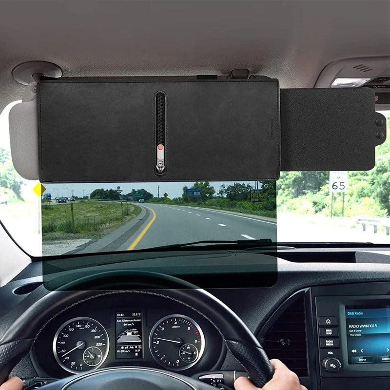 A black adjustable car sun visor extender is mounted on the roof, viewed through the windshield.