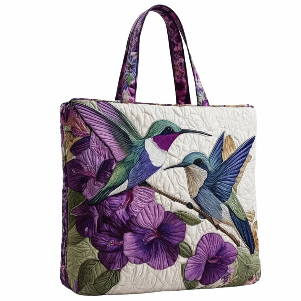 A vintage quilted tote bag featuring a purple and green floral pattern on a white background.
