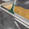 A silicone scraper broom and squeegee is shown cleaning a glass surface with a yellow cleaning cloth.